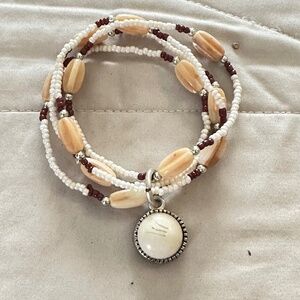 Stretchy beaded bracelet silver tone charm & white bead Cream/tan/brown.